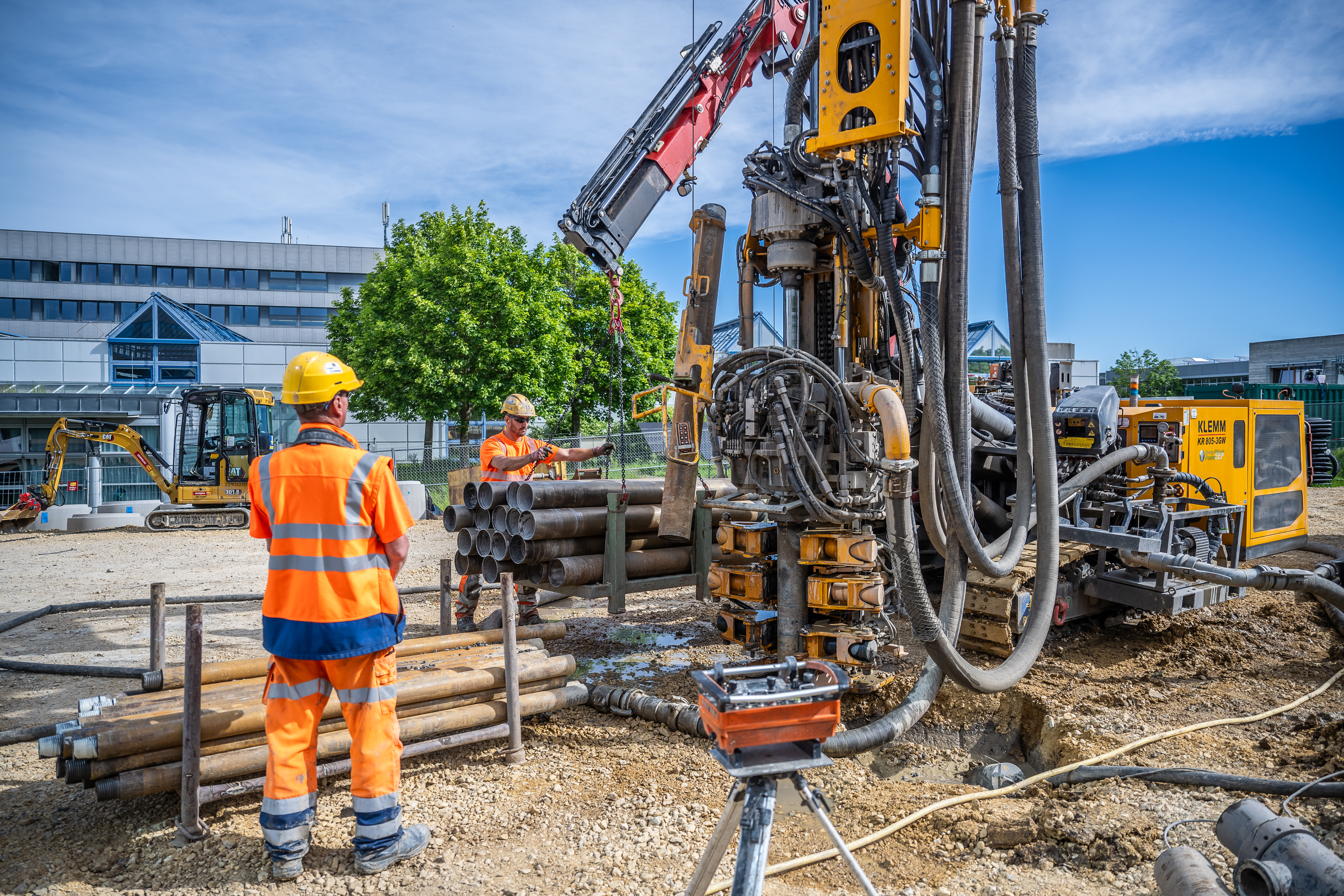 Bauer Resources Mitarbeiter heben eines der Bohrrohre für die Herstellung der Erdwärmesonden in Position