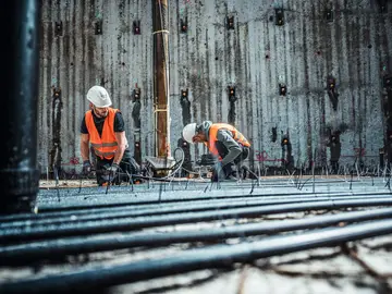 Bauer Resources Mitarbeiter bei der Rohrleitungsinstallation für Geothermie in einer Baugrube