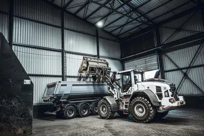 Radlader belädt kontaminierten Boden auf einen LKW für Weitertransport im Bodenreinigungszentrum von Bauer Resources in Duisburg